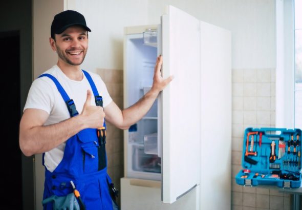 professional_young_repairman_worker_uniform_cap_with_modern_toolbox_with_equipment_after_repair_refrigerator_kitchen